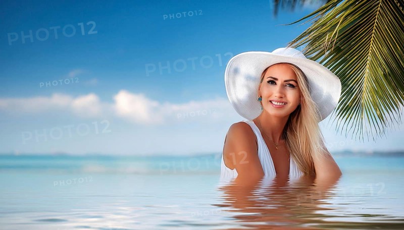 An attractive young woman in a sun hat on the beach swimming in the sea, in the Caribbean