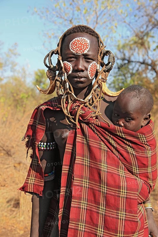 South Ethiopia, in Maco National Park, Mursi tribe, Mursi woman with baby, painted skin and headdress, Ethiopia, Africa