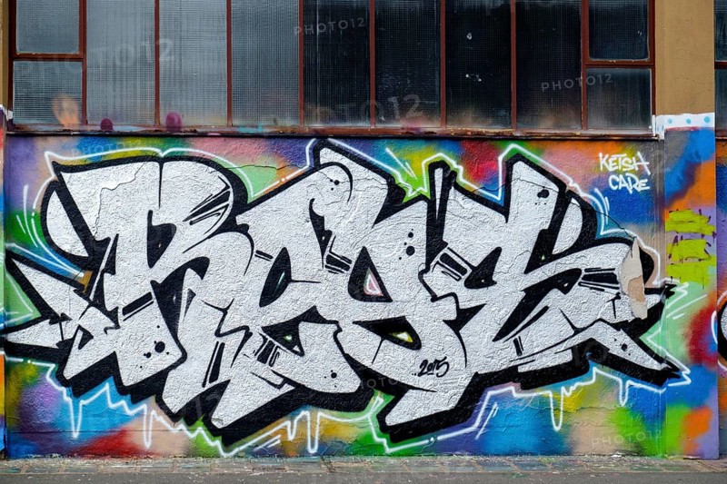 White and black graffiti with colourful accents in front of a window wall, Landau, Rhineland-Palatinate, Germany, Europe