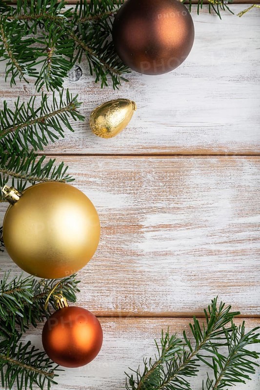 Christmas or New Year composition. Decorations, box, golden balls, cinnamon, fir and spruce branches, cup of coffee, on a white wooden background. Top view, copy space, flat lay