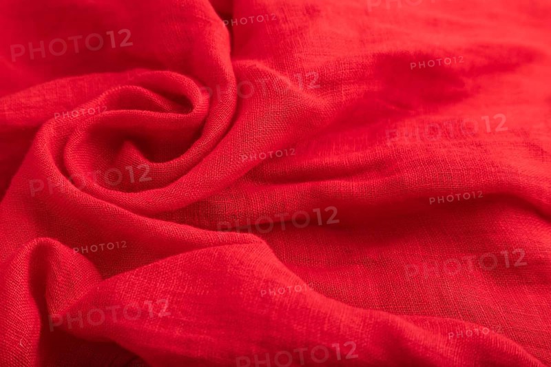 Fragment of red silk tissue. Side view, natural textile background and texture. wave concept, abstract, spiral form