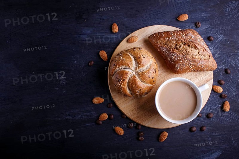 Cup of coffee with cream and buns on a black background. top view, flat lay, copy space