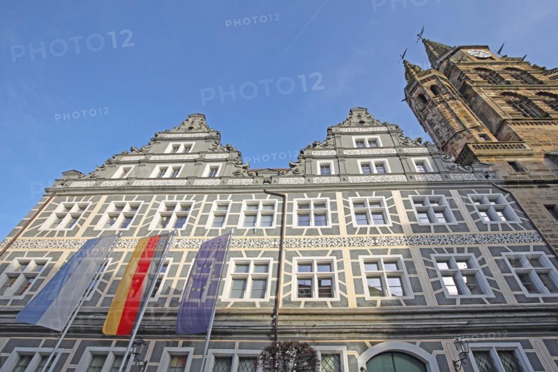 Renaissance building with sgraffiti and flags, EU flag, German state flag, Bavarian state flag and tower of St. Gumbertus church, view from below, grey, white, former court chancellery, administrative court, Montegelaplatz, Ansbach, Middle Franconia, Franconia, Bavaria, Germany, Europe