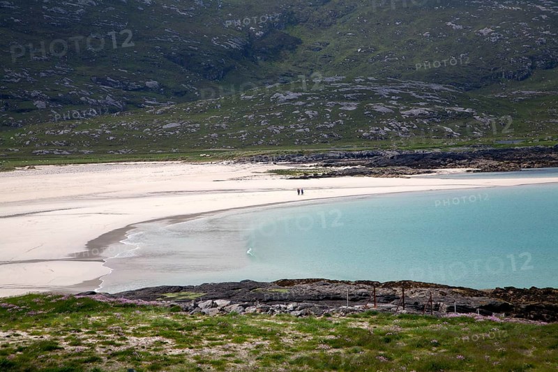 A couple walking in the distance on sandy beach in Halaman bay, Barra, Outer Hebrides, Scotland, UK