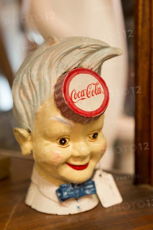 Old vintage Coca Cola advertising sign in form of boy's head inside antiques centre, Marlesford Mill, Suffolk, England, UK