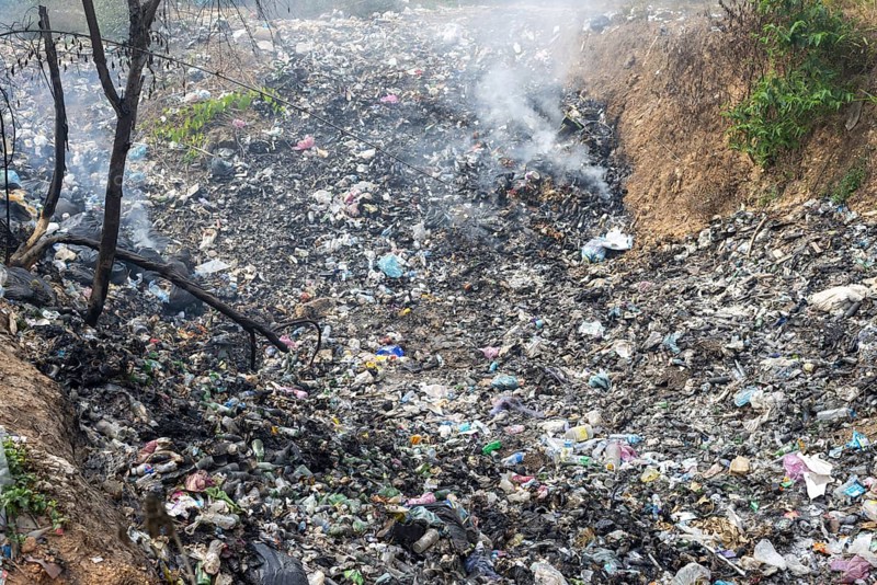 Coking rubbish dump, rubbish pit with waste and plastic rubbish, karst landscape near Vang Vieng, Vientiane province, Laos, Asia