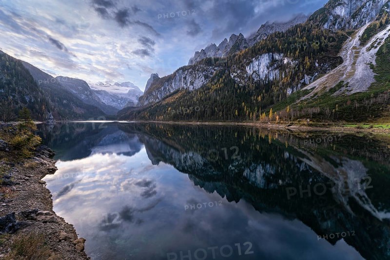 The Vordere Gosausee lake in the morning in autumn with a view of the Dachstein mountain range. The Gosaukamm on the right. Cloudy and blue sky. Reflection. Vorderer Gosausee, Gosau, Gosau valley, Salzkammergut, Upper Austria, Austria, Europe