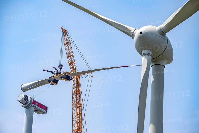 Erection of an Enercon E-160 wind turbine, rear, assembly of the first blade, 4 turbines with a total output of 22 megawatts replace 9 older wind turbines from the manufacturer Enercon (E-58 model series), front, they were in operation for over two decades, Lower Rhine, North Rhine-Westphalia, Germany, Europe