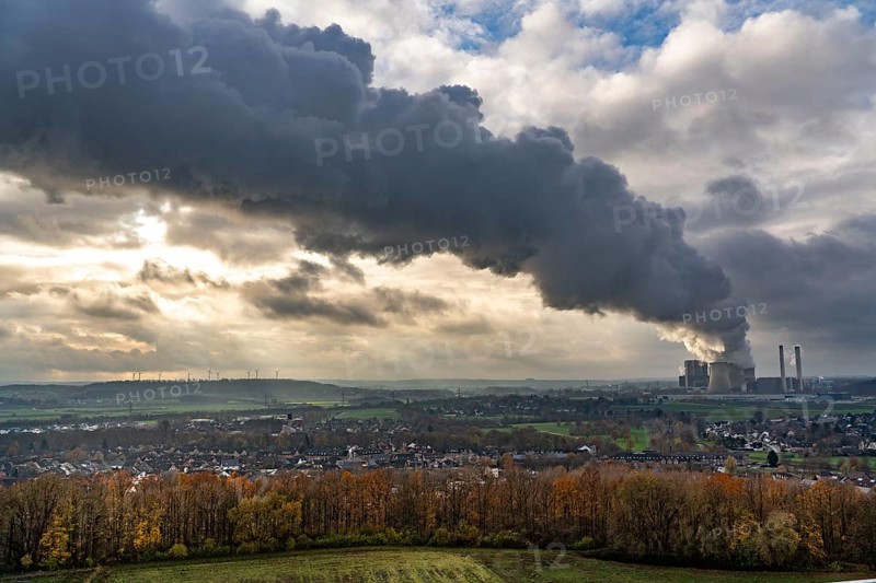 Long smoke, water vapour plume of the Weisweiler lignite-fired power plant of RWE Power AG in Eschweiler-Weisweiler, base load power plant, burns lignite from the Inden opencast mine, on the left Nierchen slagheap with wind farm, North Rhine-Westphalia, Germany, Europe