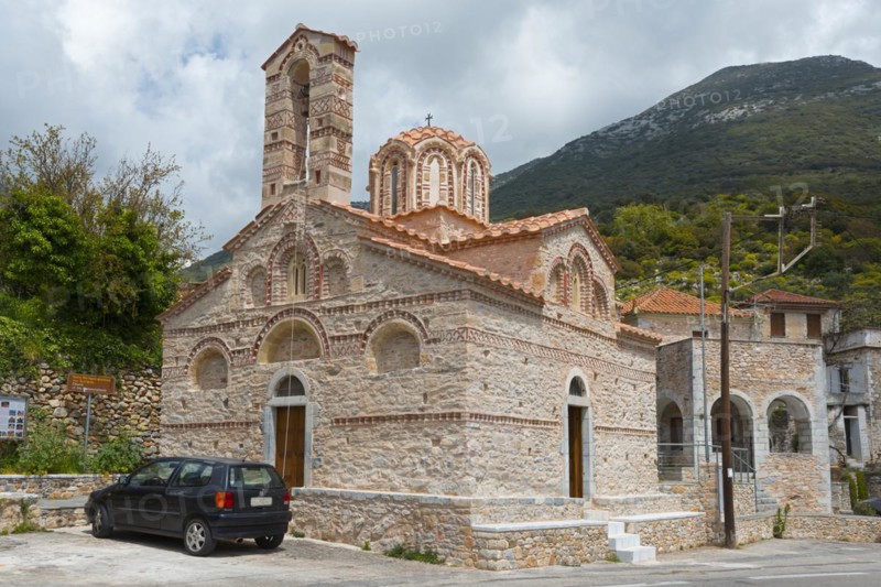 Stone Orthodox church under a cloudy sky with a car in front of it on a wooded hillside, Byzantine Church, Holy Church of Metamorphosis, Lagkada, Langada, Mani, Peloponnese, Greece, Europe