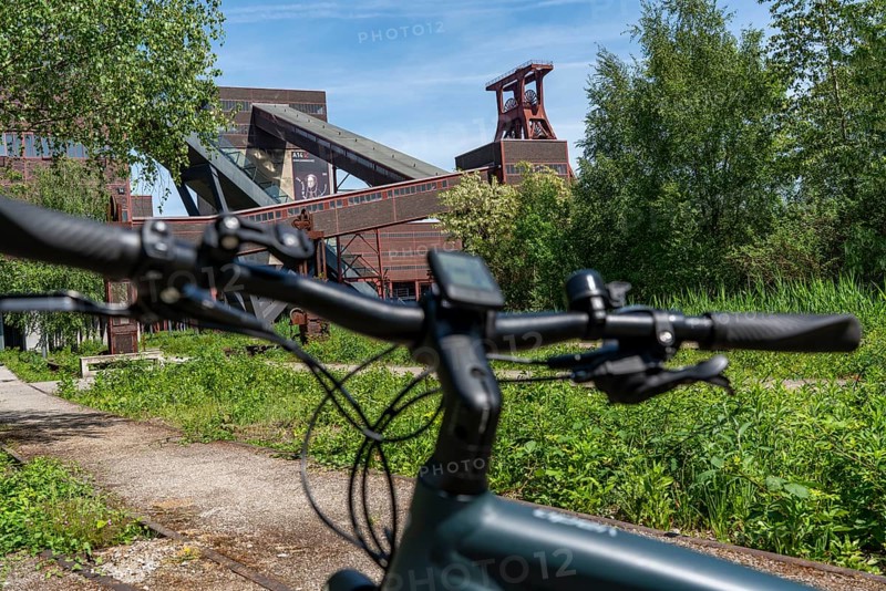 Cycling in the Ruhr region, by bike, e-bike, at the Zollverein Coal Mine Industrial Complex World Heritage Site, double trestle winding tower shaft XII, Essen, North Rhine-Westphalia, Germany, Europe