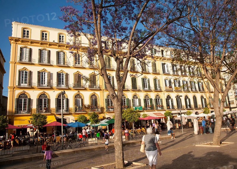 People sitting outside popular cafes on a sunny afternoon in Plaza de la Merced, Malaga, Spain, Europe