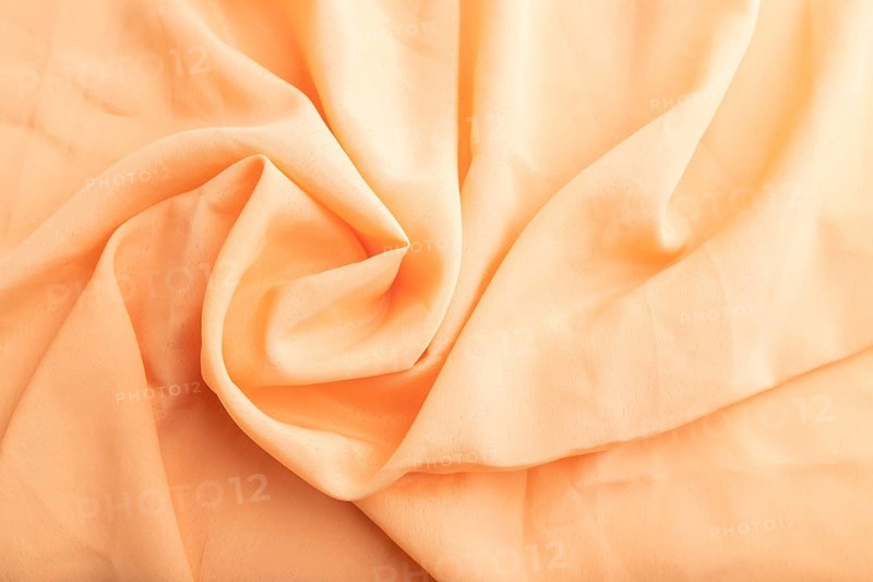 Fragment of orange linen tissue. Top view, flat lay, natural textile background and texture. wave concept, abstract, spiral form