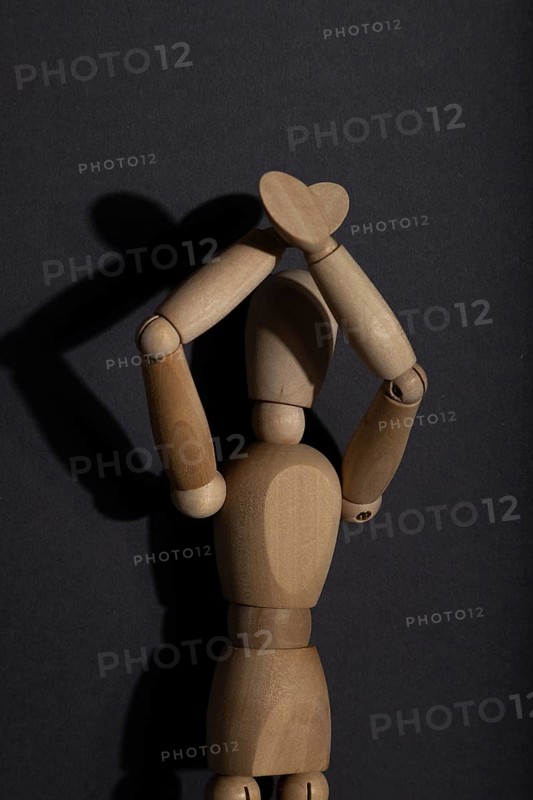 Wooden mannequin stands with raised hands on gray background. protest, attention concept. copy space, hard light