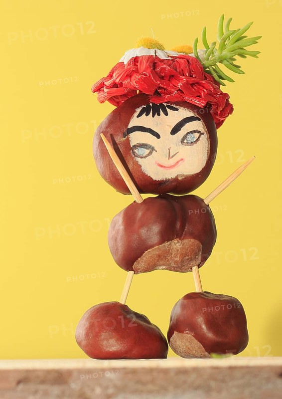 Funny chestnut figure with hat standing in front of a yellow wall, North Rhine-Westphalia, Germany, Europe