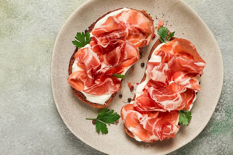 Sandwich with cream cheese and prosciutto, on black grain bread, breakfast, homemade