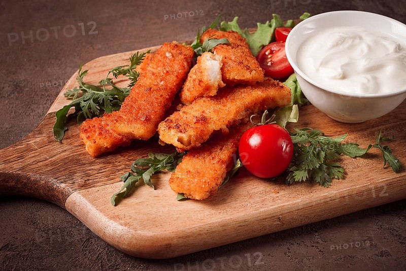 Fried fish nuggets, with white sauce, arugula and cherry, no people