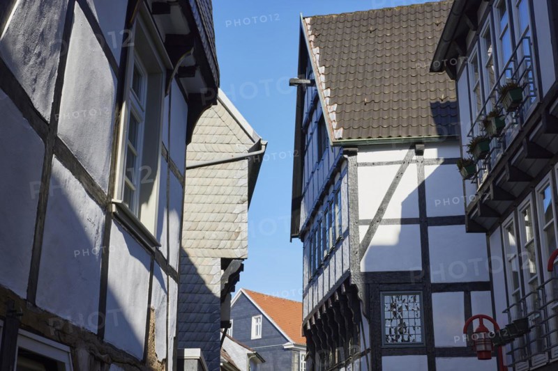 Tightly built and angled gables of half-timbered houses in grazing light against a blue sky in the old town of Hattingen, Ennepe-Ruhr district, North Rhine-Westphalia, Germany, Europe