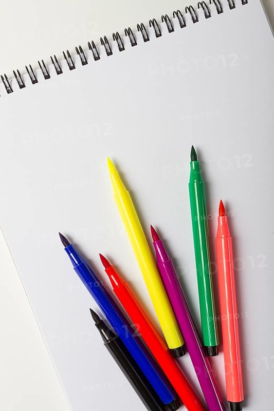 Watercolor pens brush, assortment, on a drawing album, artist's desk, top view, close-up, selective focus