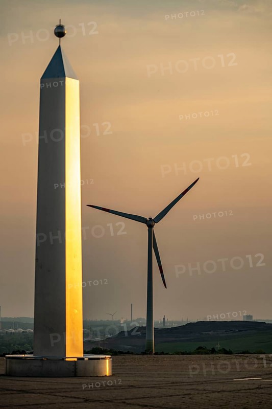 Evening atmosphere on the Hoheward spoil tip, the largest spoil tip in the Ruhr area, between Herten and Recklinghausen, sundial, obelisk of the horizontal observatory, wind power station on the Hoppenbruch spoil tip, Gelsenkirchen, North Rhine-Westphalia, Germany, Europe
