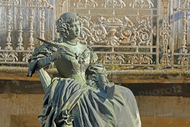 Monument with sculpture of Marquise de Sévigné, Madame, French, nobility, noblewoman, woman, aristocracy, seated, historical, noble, elegant, distinguished, dress, gown, skirt, baroque, pen, writer, author, balcony railing, decorations, metal railing, Art Nouveau, Sevigne, Place Sévigné, Grignan, Drôme, Tricastin, Provence, France, Europe