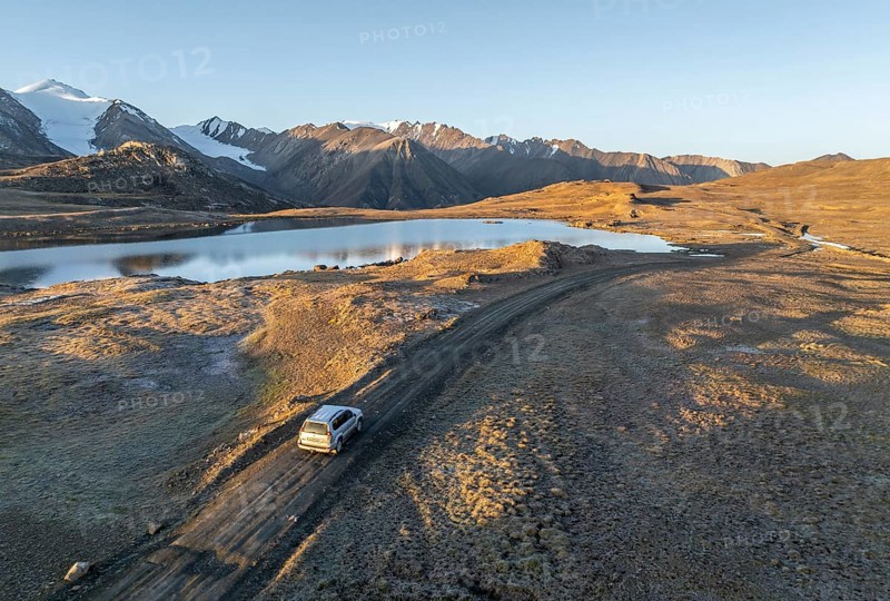 Aerial view, off-road vehicle on gravel track, mountain peak and mountain lake, evening mood, Arabel Lake at Arabel Pass, Issyk Kul Province, Kyrgyzstan, Asia