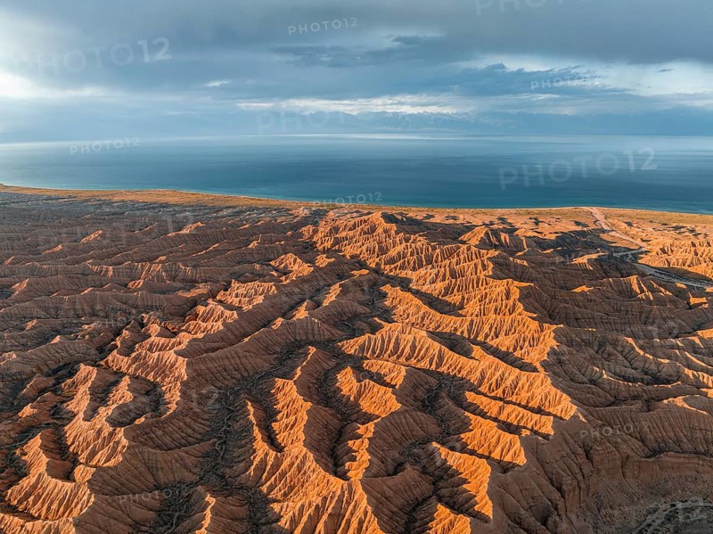 Landscape of eroded hills, badlands at sunset, Issyk Kul Lake in the background, aerial view, Canyon of the Forgotten Rivers, Issyk Kul, Kyrgyzstan, Asia