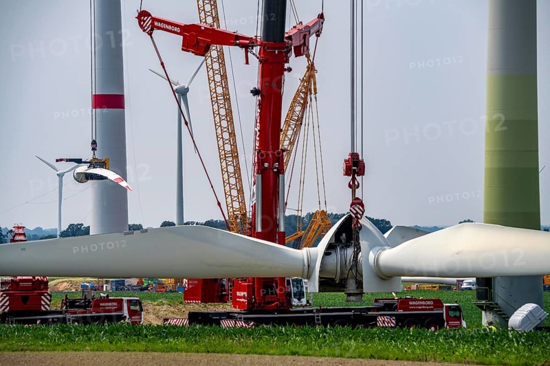 Dismantling of a wind power plant in a wind farm near Issum, 9 older wind turbines from the manufacturer Enercon (model series E-58), front, blades being dismantled, were in operation for over two decades, will be replaced by a total of four Enercon E-160 turbines, rear, assembly of the first blade, with a total output of 22 megawatts, Lower Rhine, North Rhine-Westphalia, Germany, Europe
