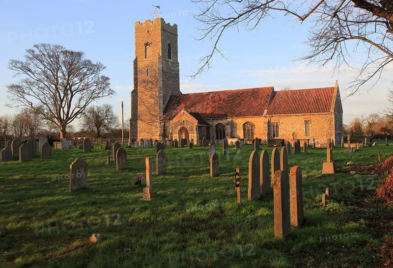Late afternoon winter golden light falls on Saint John the Baptist church, Snape, Suffolk, England, UK
