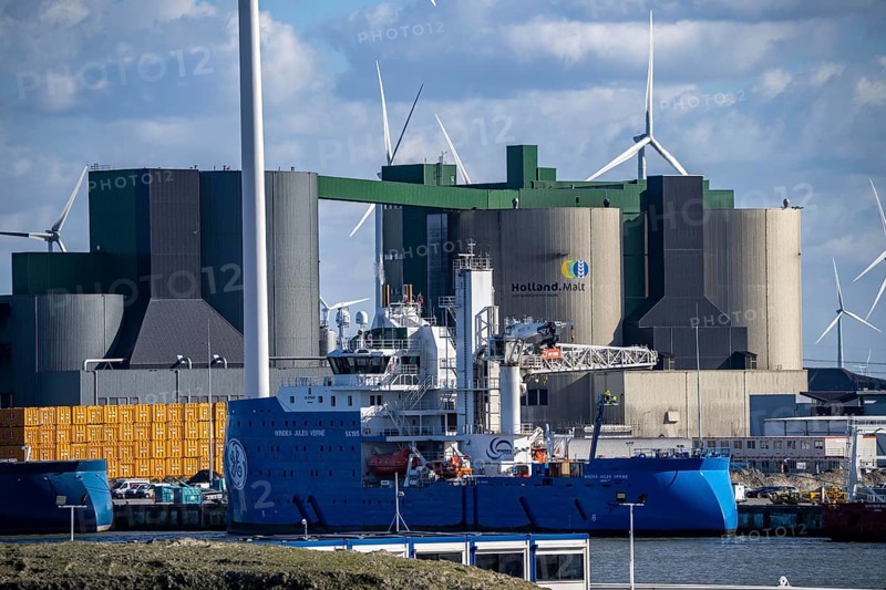 Holland Malt building, in the industrial harbour of Eemshaven, wind power plants, Netherlands