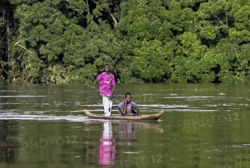 Two young men in a dugout canoe on the Sangha River, Dzanga-Sangha Complex of Protected Areas (DSPAC), Sangha-Mbaéré Prefecture, Central African Republic, Africa