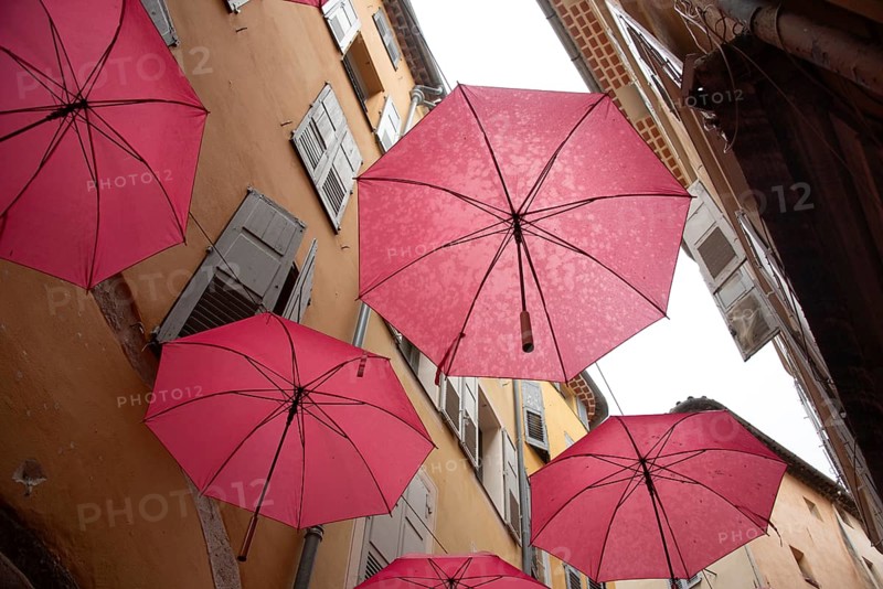 In the perfume town of Grasse, red umbrellas hang between the houses, Grasse, Provence-Alpes-Côte d'Azur, France, Europe