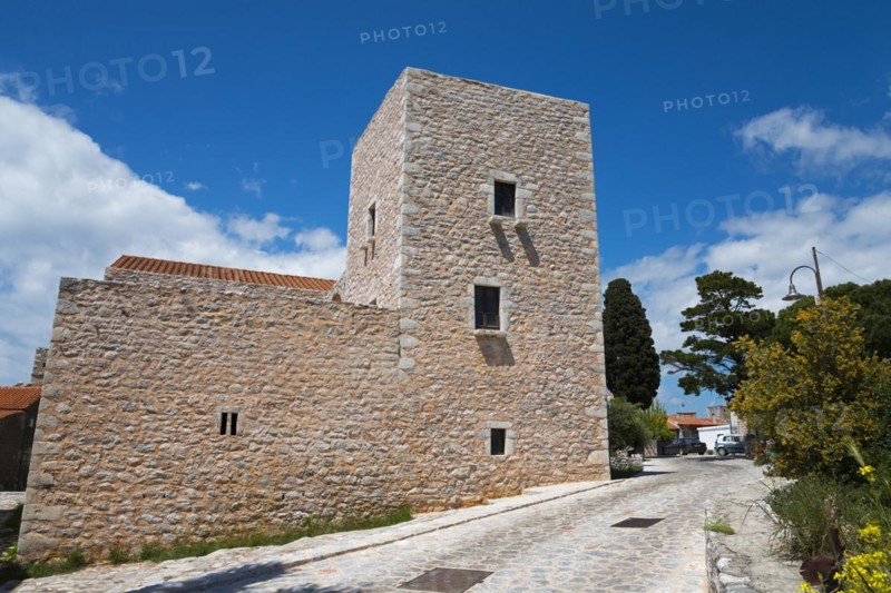 Old stone house under a bright blue sky with scattered clouds next to a cobbled path, Pikoulakis Tower, historic residential tower, museum, Areopoli, Areopolis, Tsimova, Itylo, Anatoliki Mani, Mani, Laconia, Peloponnese, Greece, Europe