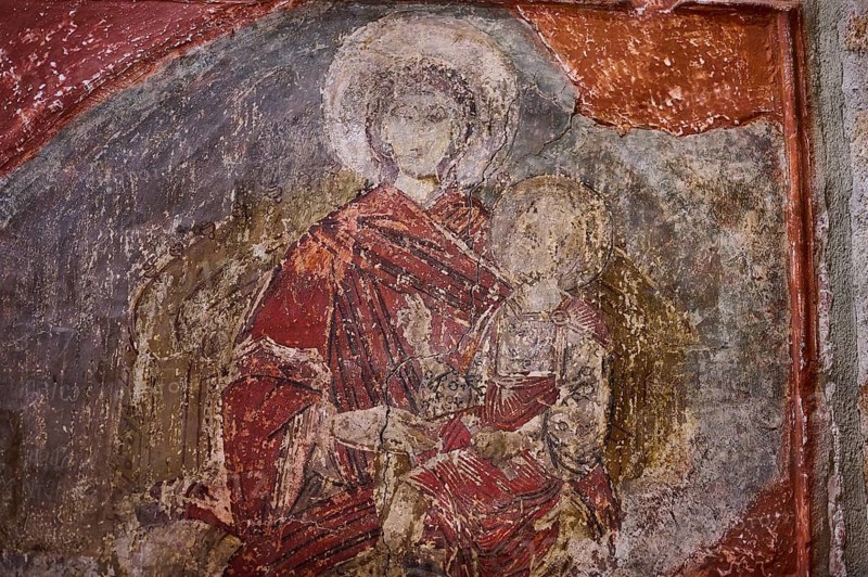 An old fresco shows a holy figure in red robes holding a child, with a weathered background, Church of the Holy Virgin, Panagia Church, Lindos, Rhodes, Dodecanese, Greek Islands, Greece, Europe