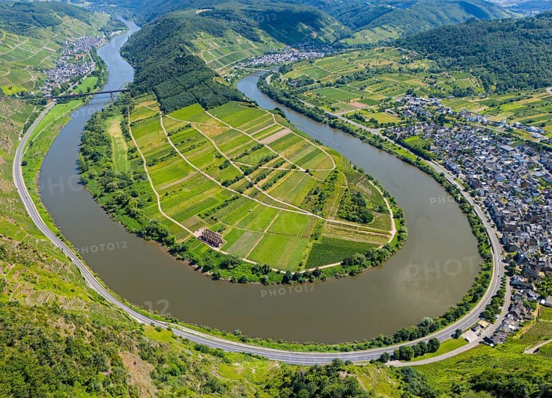 A winding river in the middle of a green, hilly landscape with vineyards, a neighbouring village and agricultural land, aerial view, Moselle, Moselle bend, Bremm, Cochem, Cochem-Zell, Rhineland-Palatinate, Germany, Europe