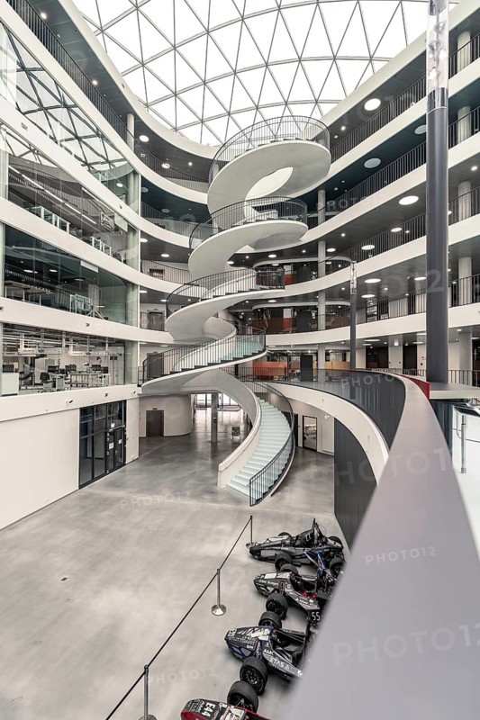 A modern, bright interior with a large spiral staircase, glass ceiling and industrial aesthetics, University of Stuttgart, Germany, Europe