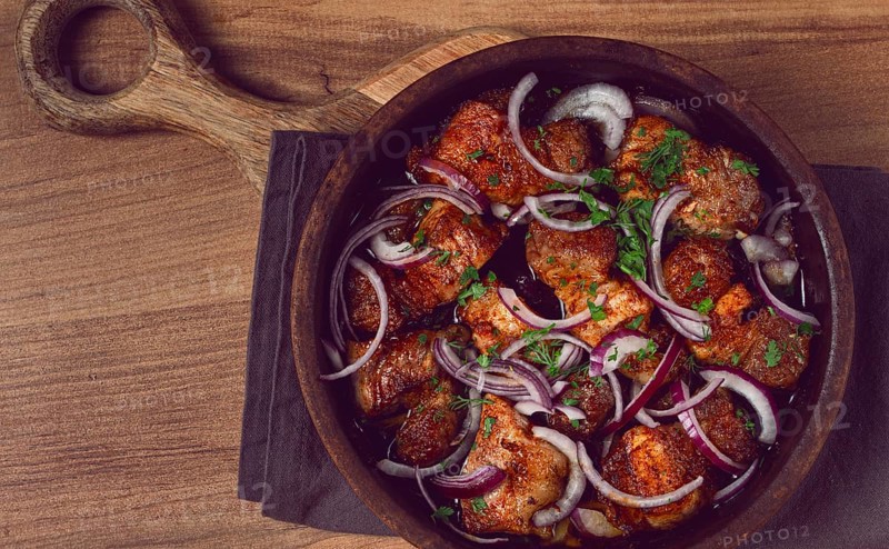 Fried meat, pork kebab, ketsi in a clay pan, with red onions and herbs, homemade, no people