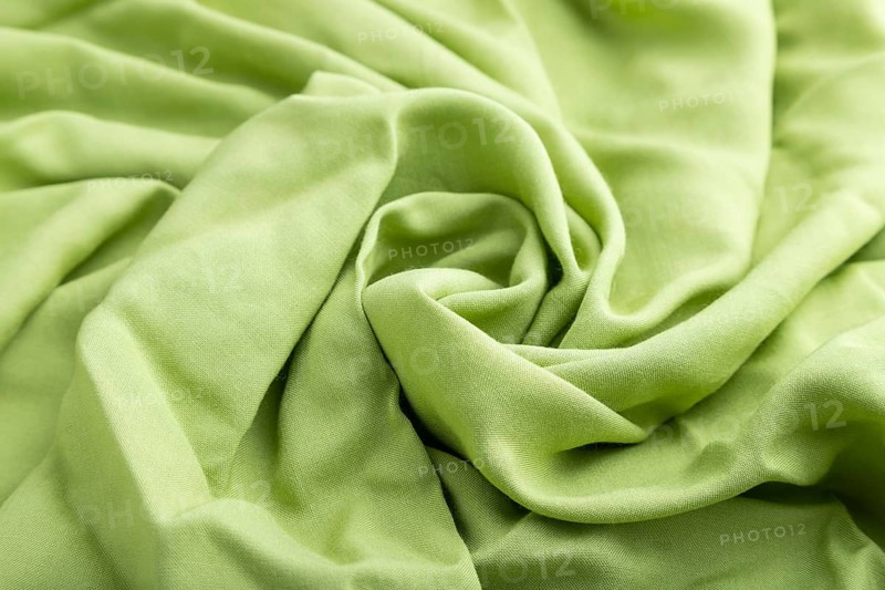 Fragment of green linen tissue. Side view, natural textile background and texture. wave concept, abstract, spiral form