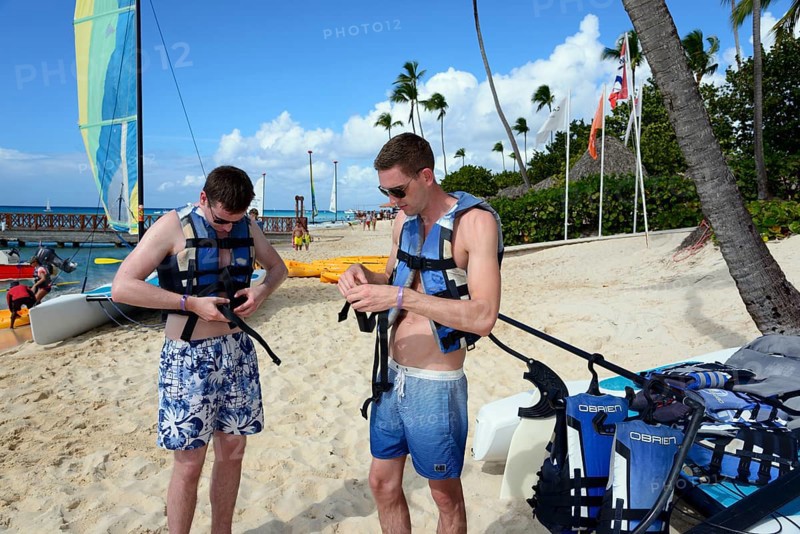 Two men prepare for sailing on sunny tropical beach, catamaran trip, Dominicus beach, Bayahibe, Dominican Republic, Hispaniola, Caribbean, America, Central America