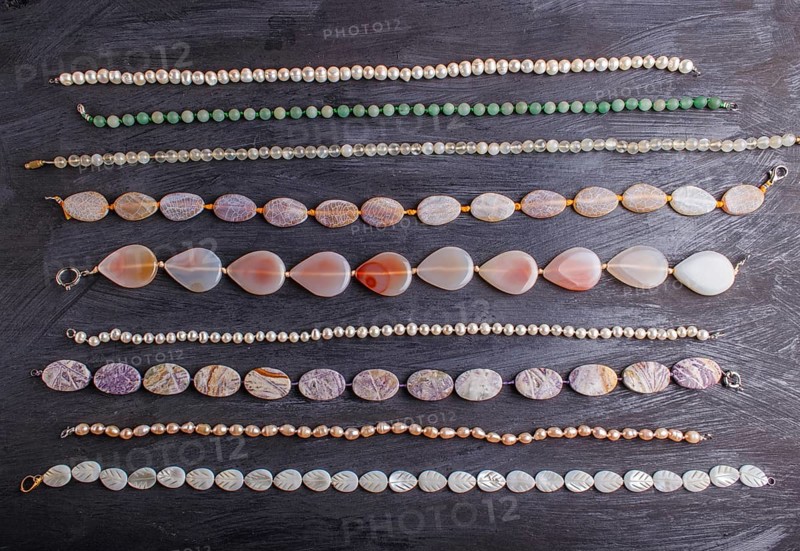 Set of semiprecious stone beads on a black background, top view