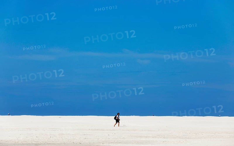 DEU, 18.06.2020, A holidaymaker walks through the knee sand on the beach of the island of Amrum, Wittdün