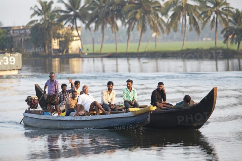 Indian men travelling on a motorboat, canal system of the backwaters, Kerala, India, Asia
