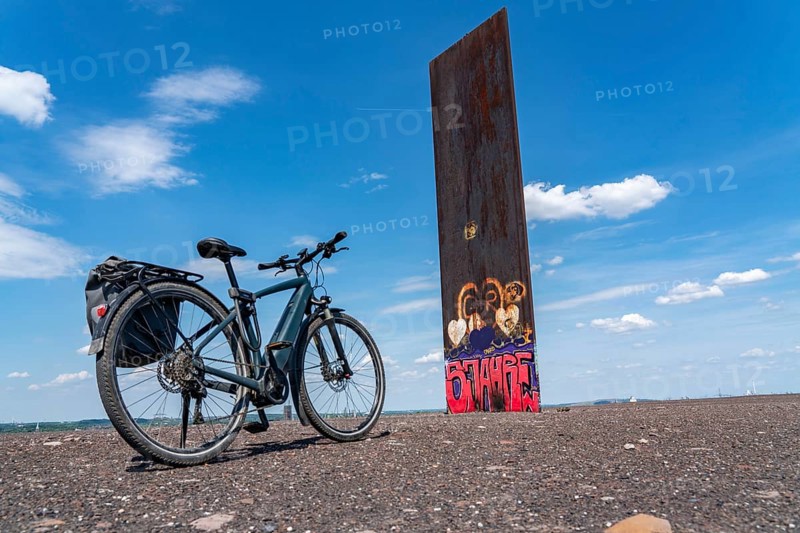 Cycling in the Ruhr area, on the Schurenbach slag heap, Bramme landmark for the Ruhr area by artist Richard Serra, Essen, North Rhine-Westphalia, Germany, Europe