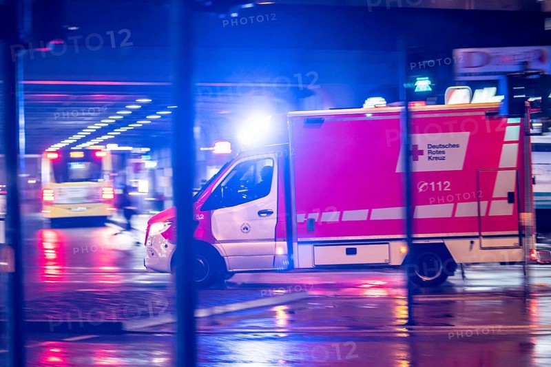 Ambulance on alarm, DRK, Essen fire brigade, rainy weather, city centre, evening, Essen, North Rhine-Westphalia, Germany, Europe