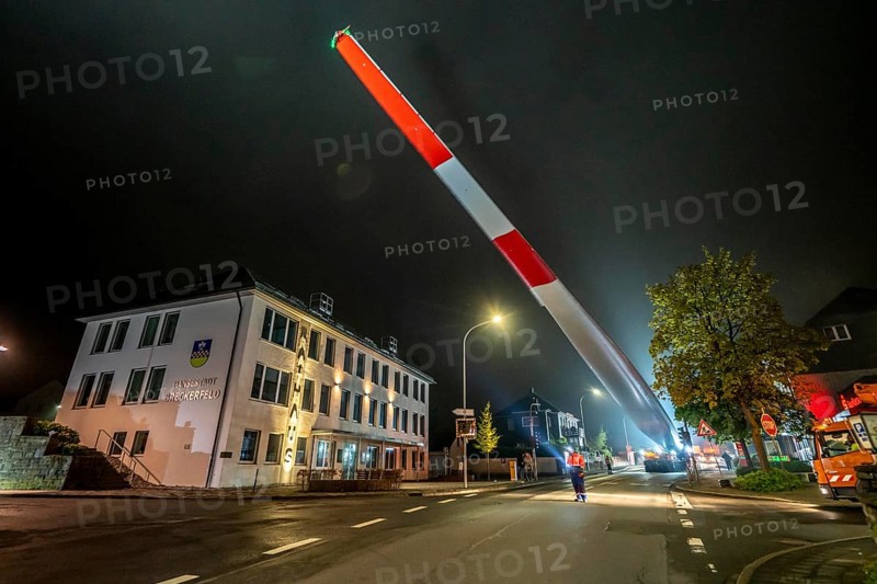 Transport of a 68 metre long, 22 tonne blade of a wind turbine, here in Breckerfeld, with a self-propelled Blade-Lifter vehicle, over a 40 km long route, over 2 nights, in the Bergisches Land, through towns, villages, over country roads, narrow through roads, to the construction site of the wind turbine near Hagen, North Rhine-Westphalia, Germany, Europe