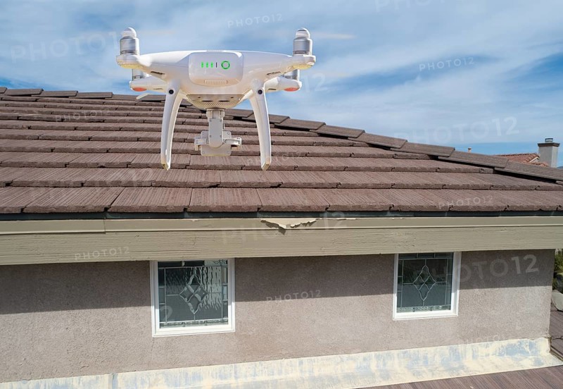 Quadcopter UAV drone flying A residential roof inspection