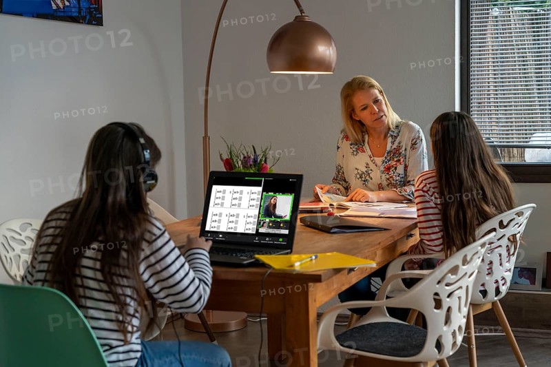 Homeschooling, during the lockdown in January 2021, mother helps her two daughters, at home, learning, a girl is in video lessons with her class, school closures, distance learning, effects of the corona crisis in Germany