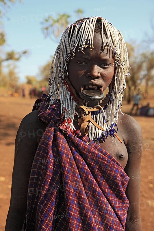 South Ethiopia, in Maco National Park, Mursi tribe, young Mursi woman, plate-lipped woman, woman with plate in her lower lip, lip jewellery, hair plaited into small tufts, Ethiopia, Africa