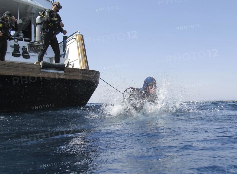 Diver jumping into the water from a dive boat, Red Sea, Egypt, Africa