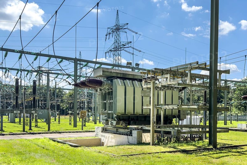 In front large transformer transformer transformer power transformer in transformer station, on the left hanging suspended power lines in the background overhead line mast high-voltage mast power mast support mast suspension of overhead electric line overhead line for transmission of electric energy energy supply, Germany, Europe